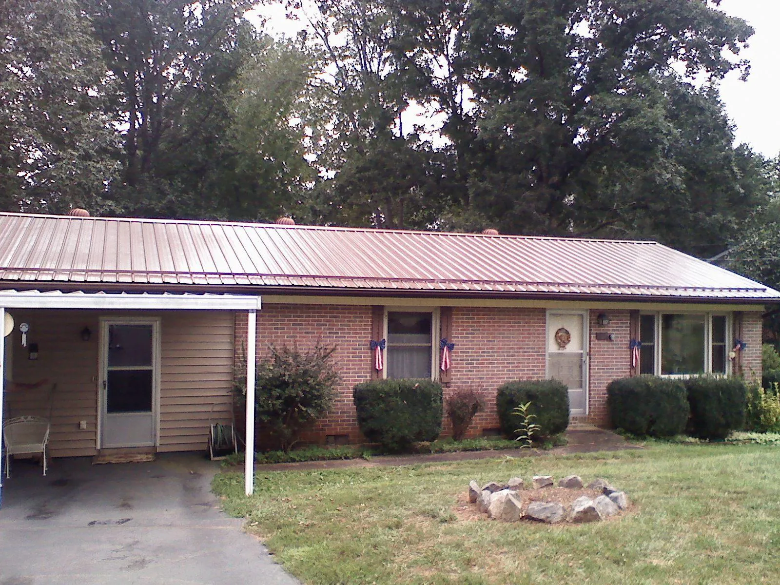 Bronze metal roof and carport on a brick ranch home — Roof Repair work by our crew in Mitchell